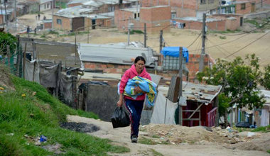 A mother carries her baby through the winding, steep streets of the settlement of Altos de la Florida, Soacha, Colombia. The majority of people in the settlement have been displaced from other areas of Colombia because of fighting and threats by various armed factions. Photo: UNHCR/S. Rich