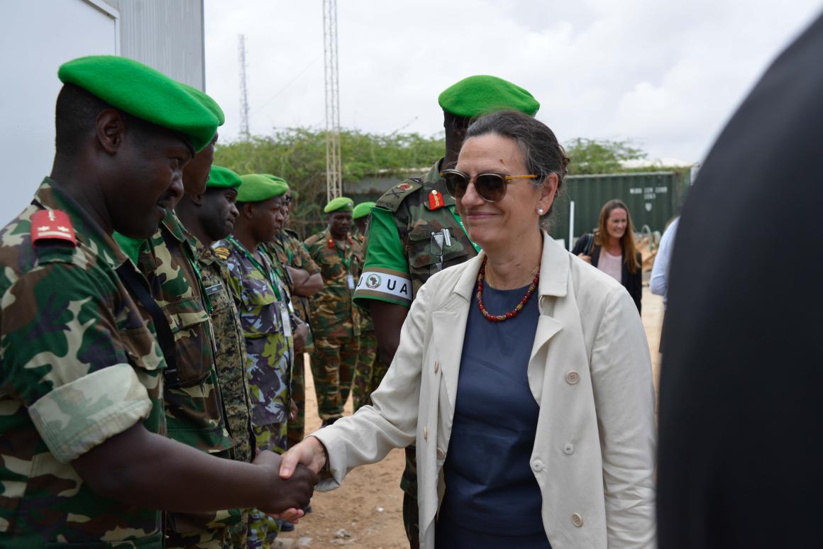 A woman shakes hands with a man in uniform